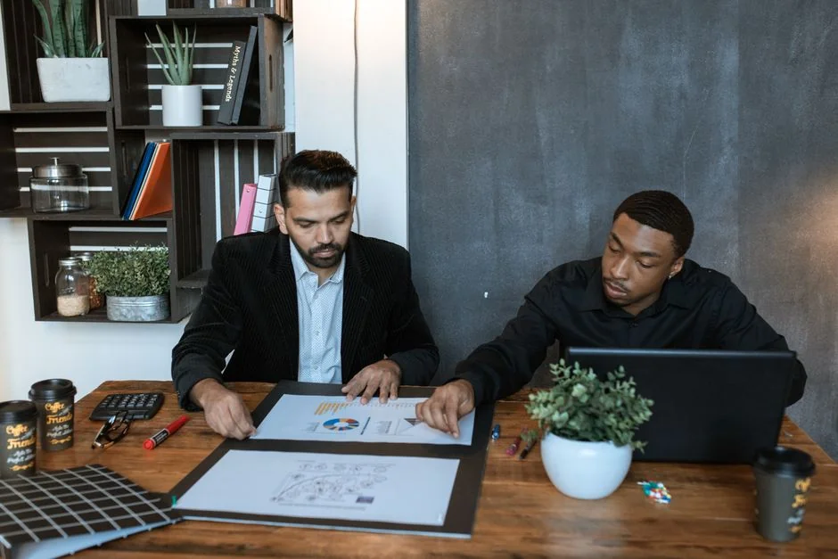 A diverse team collaborating on digital marketing strategies at a desk, using laptops and tablets.